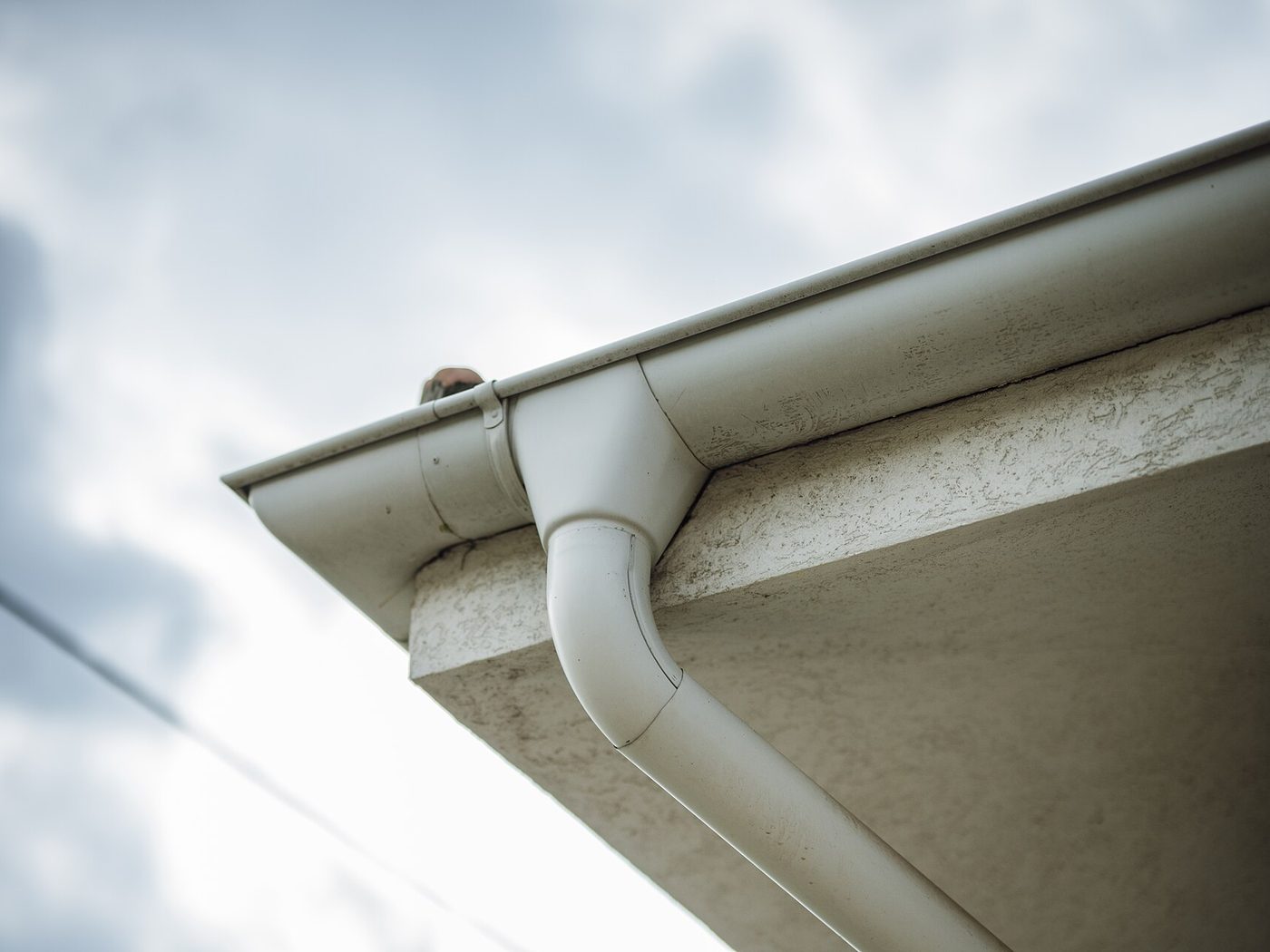 A seamless rain gutter and downspout on a house